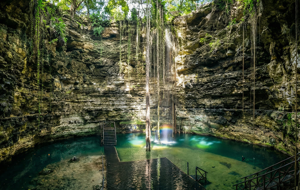Cascada en Cenote Chichikan entre piedras y naturaleza