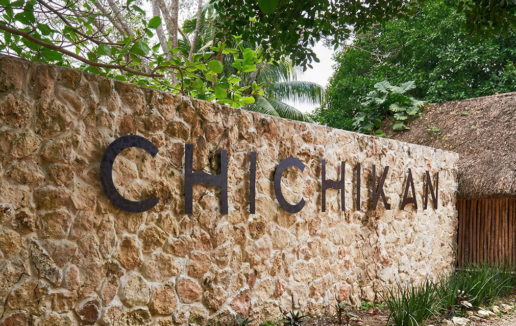 Vista aérea del Cenote Chichikan con cascada e isla central